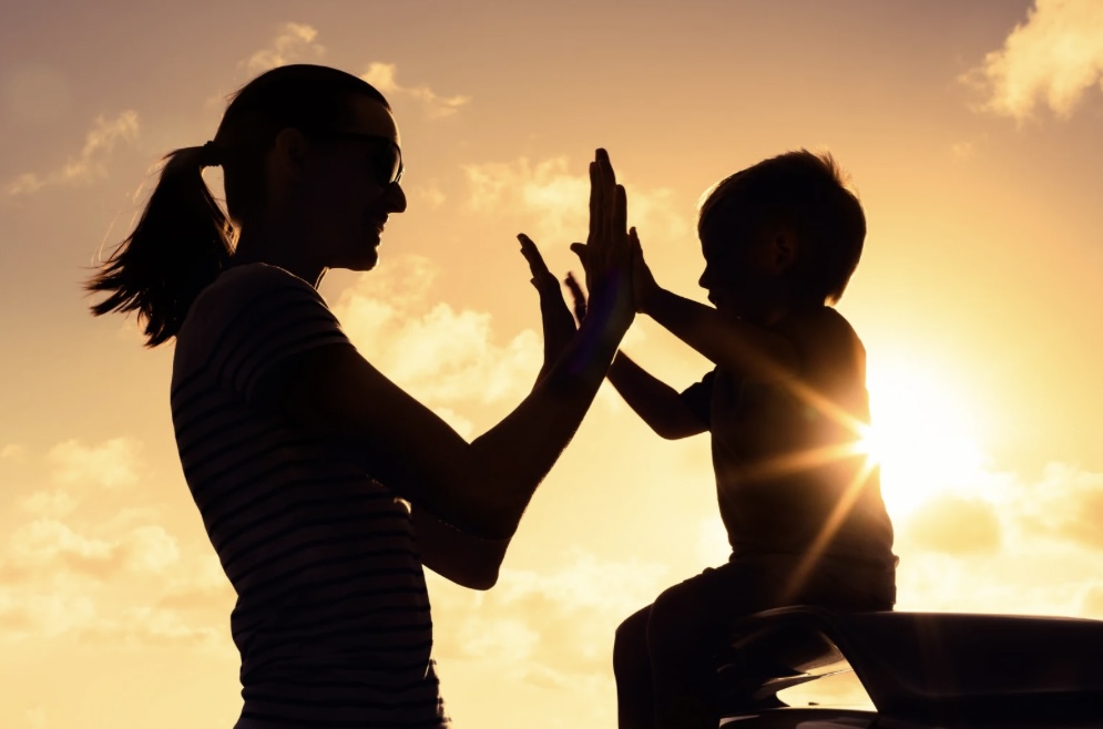 Parent and child connecting at sunset